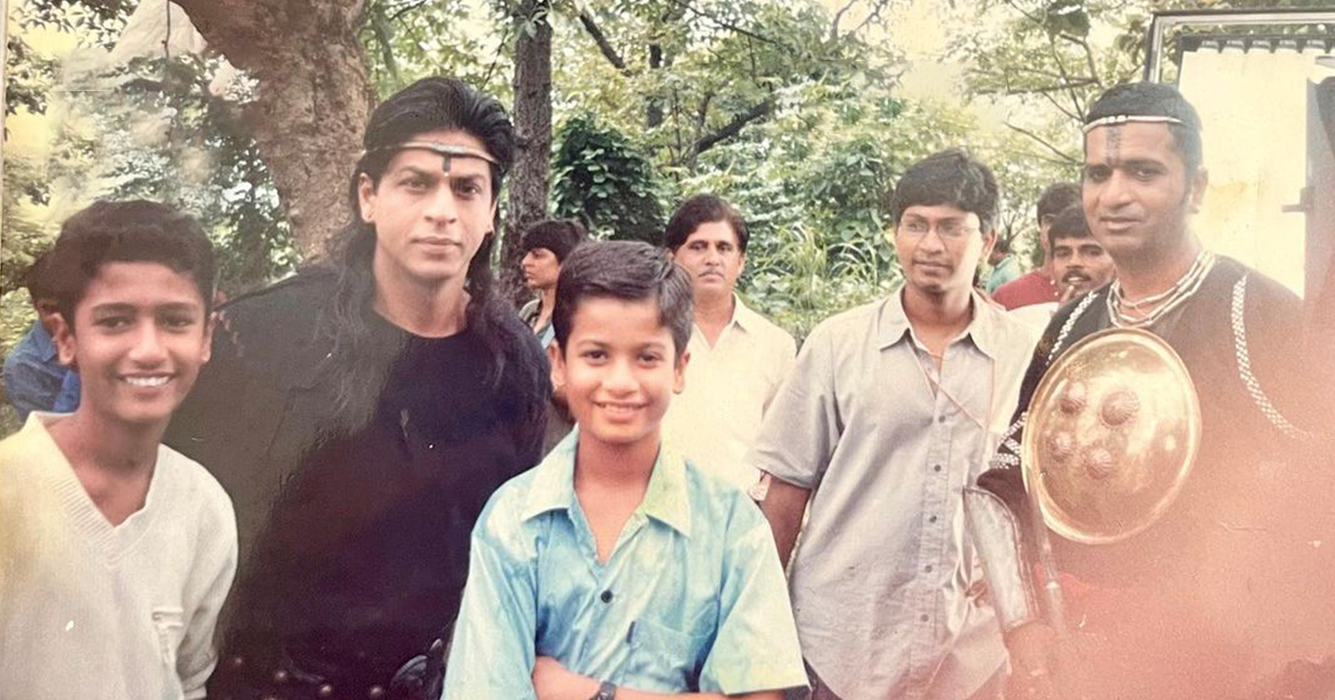 SRK के साथ इस फ़ोटो में दिखने वाला 8वीं क्लास